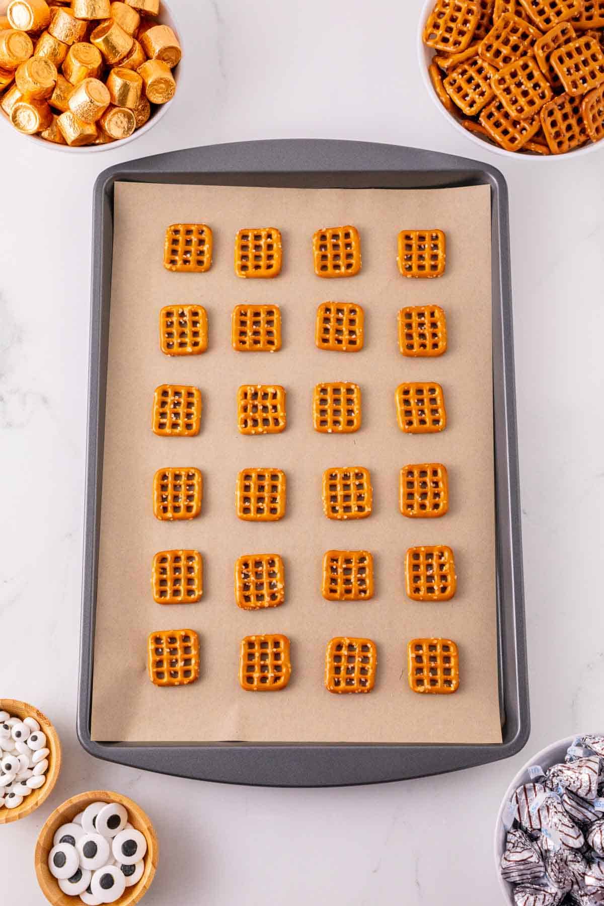snaps pretzels on a parchment lined baking sheet