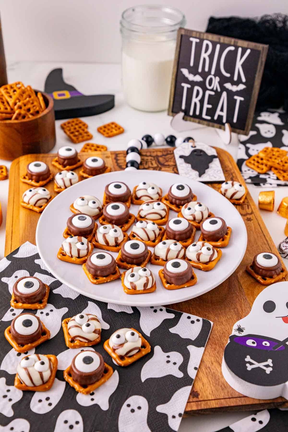 These Halloween Pretzel Rolo Bites are an easy Halloween treat made with crunchy pretzels, gooey Rolo chocolates, Hershey’s Hugs and spooky candy eyes! If you need Easy Halloween Treats, Halloween Pretzel Treats, Halloween Party Food, Halloween Snacks for Kids or quick No Fuss Halloween Desserts, these sweet and salty bites are perfect. They’re ready with just 10 minutes of prep and 3 minutes in the oven, making them a fun choice for Halloween Party Snacks, Classroom Halloween Treats, Halloween Candy Treats and Spooky Halloween Food. Add candy eyeballs to create creepy monster pretzel bites with melted chocolate and caramel. Save these Rolo Pretzel Bites for Halloween Baking Ideas, Easy Halloween Desserts, Kids Halloween Snacks, Halloween Finger Foods and simple Halloween Party Treats everyone will love!