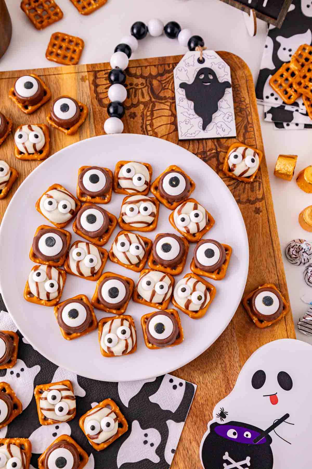 These Halloween Pretzel Rolo Bites are an easy Halloween treat made with crunchy pretzels, gooey Rolo chocolates, Hershey’s Hugs and spooky candy eyes! If you need Easy Halloween Treats, Halloween Pretzel Treats, Halloween Party Food, Halloween Snacks for Kids or quick No Fuss Halloween Desserts, these sweet and salty bites are perfect. They’re ready with just 10 minutes of prep and 3 minutes in the oven, making them a fun choice for Halloween Party Snacks, Classroom Halloween Treats, Halloween Candy Treats and Spooky Halloween Food. Add candy eyeballs to create creepy monster pretzel bites with melted chocolate and caramel. Save these Rolo Pretzel Bites for Halloween Baking Ideas, Easy Halloween Desserts, Kids Halloween Snacks, Halloween Finger Foods and simple Halloween Party Treats everyone will love!