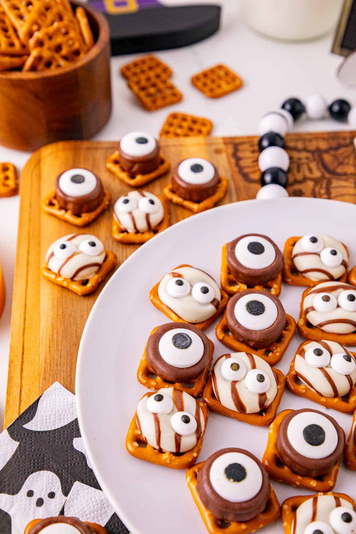 These Halloween Pretzel Rolo Bites are an easy Halloween treat made with crunchy pretzels, gooey Rolo chocolates, Hershey’s Hugs and spooky candy eyes! If you need Easy Halloween Treats, Halloween Pretzel Treats, Halloween Party Food, Halloween Snacks for Kids or quick No Fuss Halloween Desserts, these sweet and salty bites are perfect. They’re ready with just 10 minutes of prep and 3 minutes in the oven, making them a fun choice for Halloween Party Snacks, Classroom Halloween Treats, Halloween Candy Treats and Spooky Halloween Food. Add candy eyeballs to create creepy monster pretzel bites with melted chocolate and caramel. Save these Rolo Pretzel Bites for Halloween Baking Ideas, Easy Halloween Desserts, Kids Halloween Snacks, Halloween Finger Foods and simple Halloween Party Treats everyone will love!