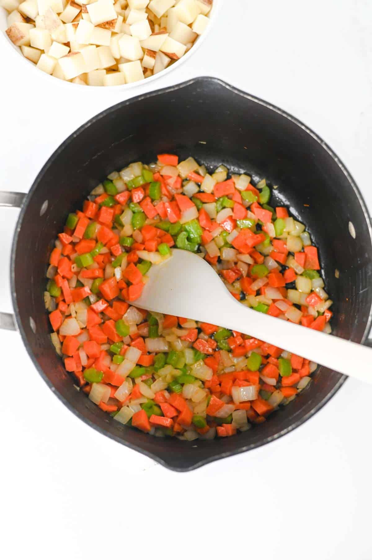 cooking diced veggies in a soup pout