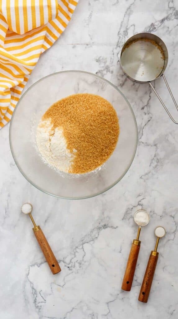brown sugar on top of flour in a mixing bowl