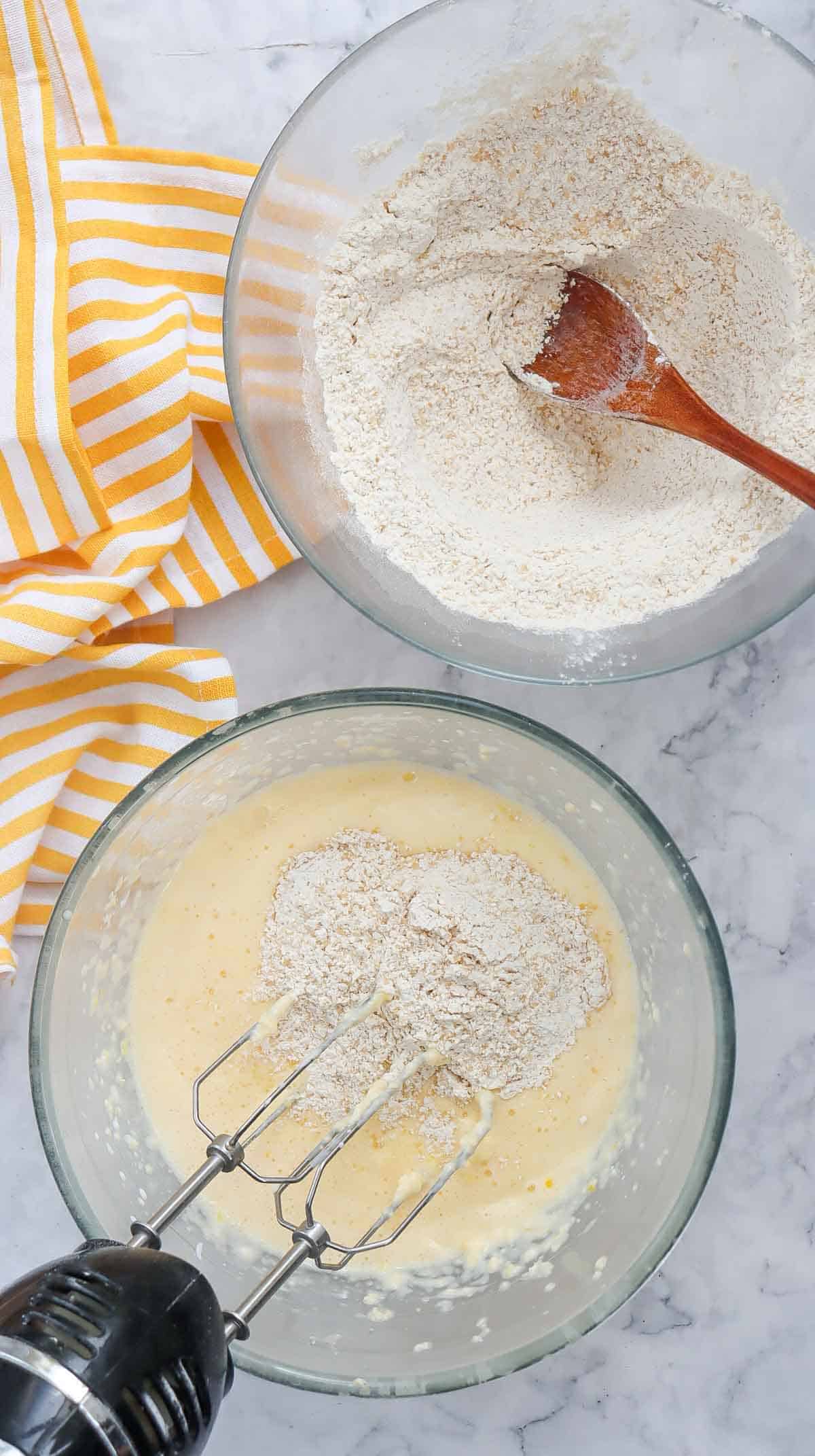 dry ingredients being added to wet ingredients in a mixing bowl