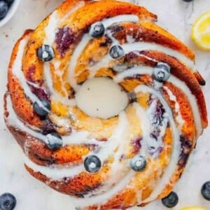 This Lemon Blueberry Bundt Cake is a moist, fluffy dessert bursting with juicy blueberries and fresh lemon flavor in every bite. If you’re searching for an Easy Lemon Blueberry Bundt Cake, Blueberry Lemon Cake, Lemon Bundt Cake Recipe, or Fresh Blueberry Dessert, this simple homemade cake is a must-try. Greek yogurt keeps the cake tender and moist while lemon zest adds the perfect bright citrus flavor. A sweet powdered sugar glaze finishes this beautiful Blueberry Bundt Cake and makes it perfect for spring baking, Easter dessert, Mother’s Day brunch, summer parties, potlucks, or afternoon coffee. Save this Lemon Blueberry Cake Recipe when you need Easy Bundt Cake Recipes, Lemon Desserts, Blueberry Desserts, Spring Cake Recipes, or a delicious dessert using fresh blueberries!