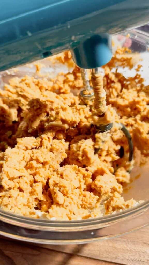 electric mixer creaming together peanut butter, sugar and cream cheese in a mixing bowl