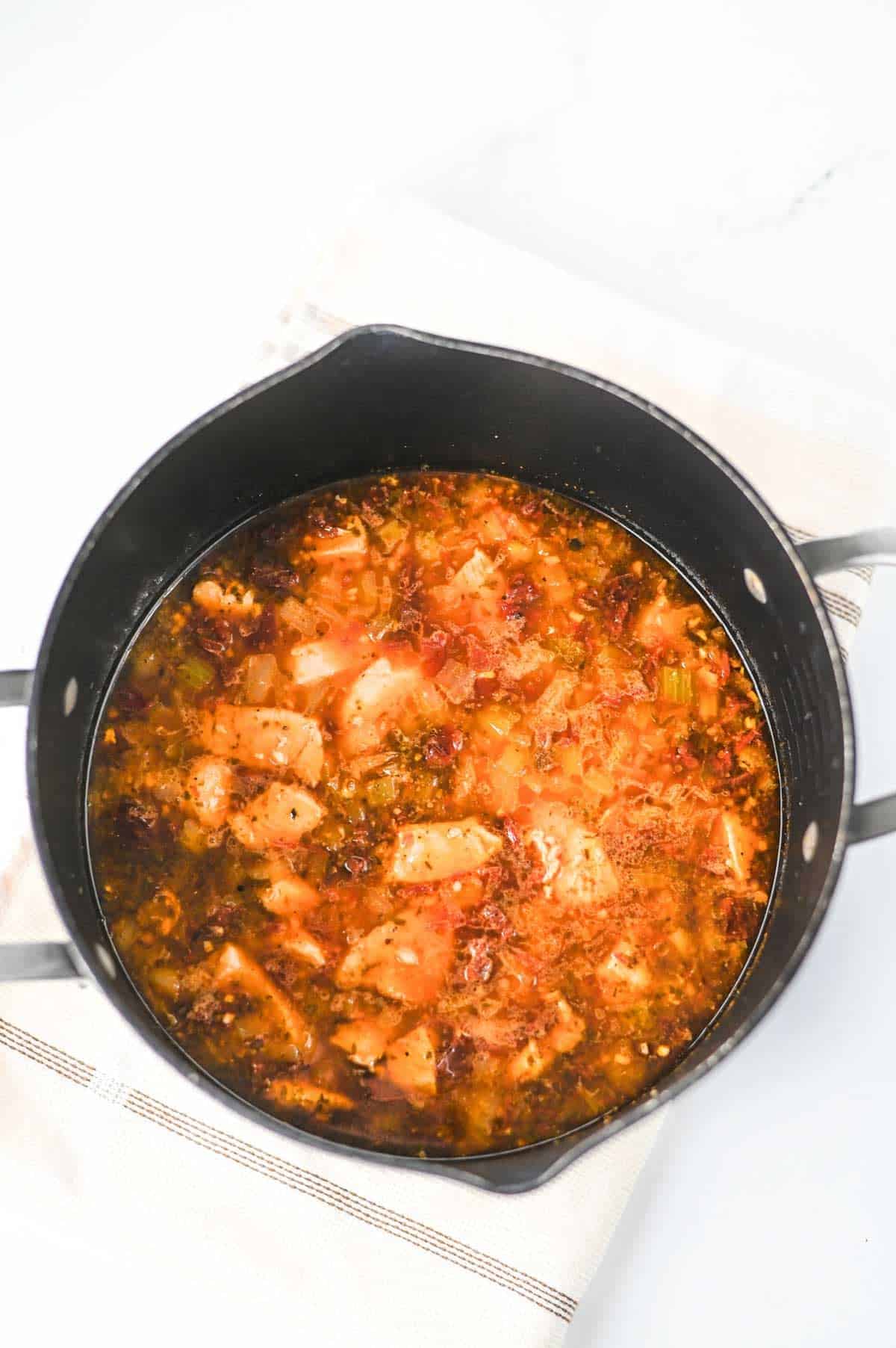 marry me chicken gnocchi soup simmering in a pot