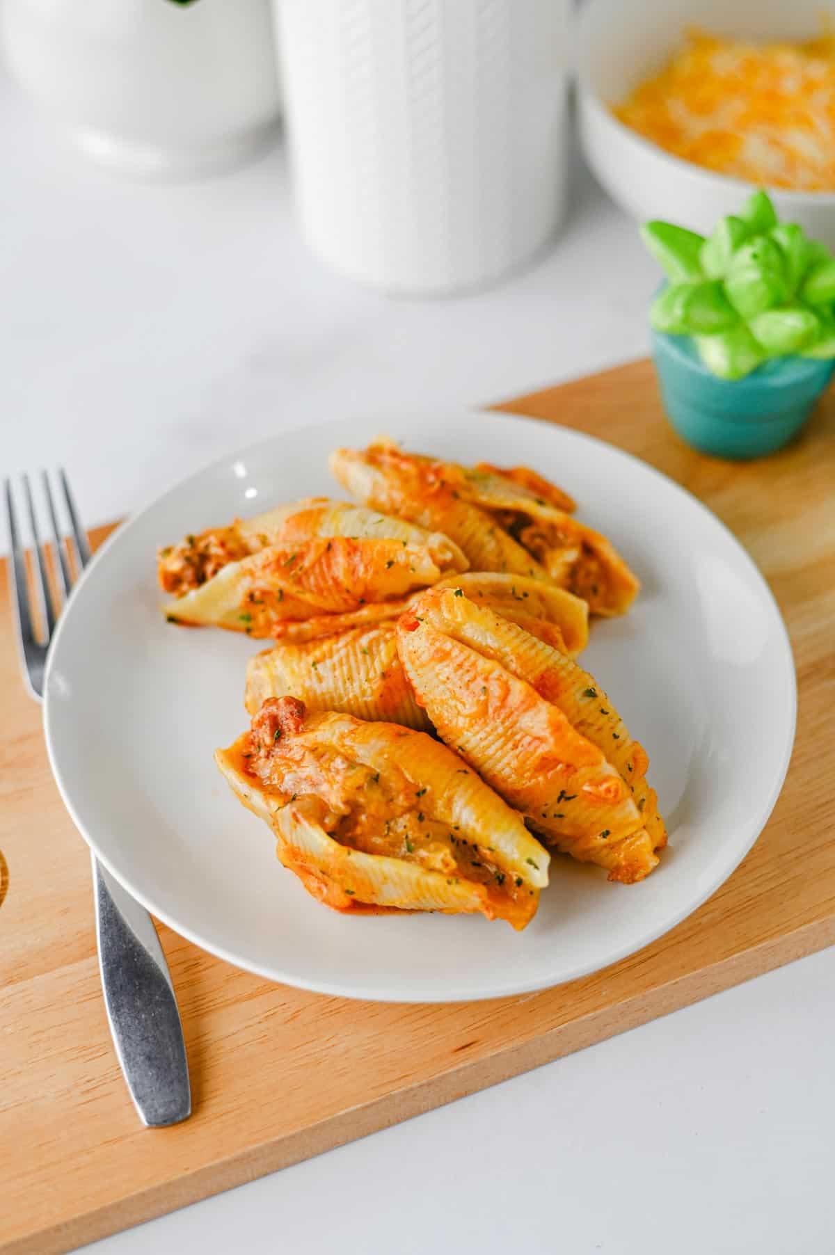 Mexican Stuffed Shells are an easy, cheesy dinner packed with bold Tex-Mex flavor! Jumbo pasta shells are filled with seasoned ground beef, taco seasoning, and cream cheese, then topped with enchilada sauce and shredded fiesta blend cheese before baking until hot and bubbly. This Mexican Stuffed Shells recipe is perfect when you need easy ground beef recipes for dinner, family friendly dinner ideas, quick weeknight meals, or a fun twist on classic stuffed shells. Add this cheesy ground beef casserole to your list of easy Mexican dinner recipes, taco inspired meals, pasta dinner ideas, and comfort food recipes. With simple ingredients and just 15 minutes of prep, these enchilada stuffed shells are great for busy nights, Taco Tuesday, or anytime you're craving cheesy Mexican pasta!