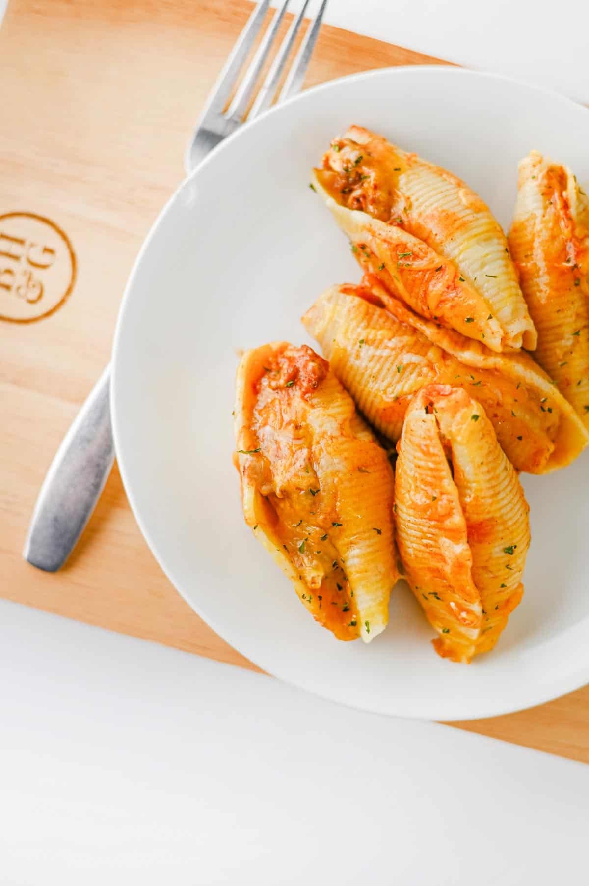 Mexican Stuffed Shells are an easy, cheesy dinner packed with bold Tex-Mex flavor! Jumbo pasta shells are filled with seasoned ground beef, taco seasoning, and cream cheese, then topped with enchilada sauce and shredded fiesta blend cheese before baking until hot and bubbly. This Mexican Stuffed Shells recipe is perfect when you need easy ground beef recipes for dinner, family friendly dinner ideas, quick weeknight meals, or a fun twist on classic stuffed shells. Add this cheesy ground beef casserole to your list of easy Mexican dinner recipes, taco inspired meals, pasta dinner ideas, and comfort food recipes. With simple ingredients and just 15 minutes of prep, these enchilada stuffed shells are great for busy nights, Taco Tuesday, or anytime you're craving cheesy Mexican pasta!