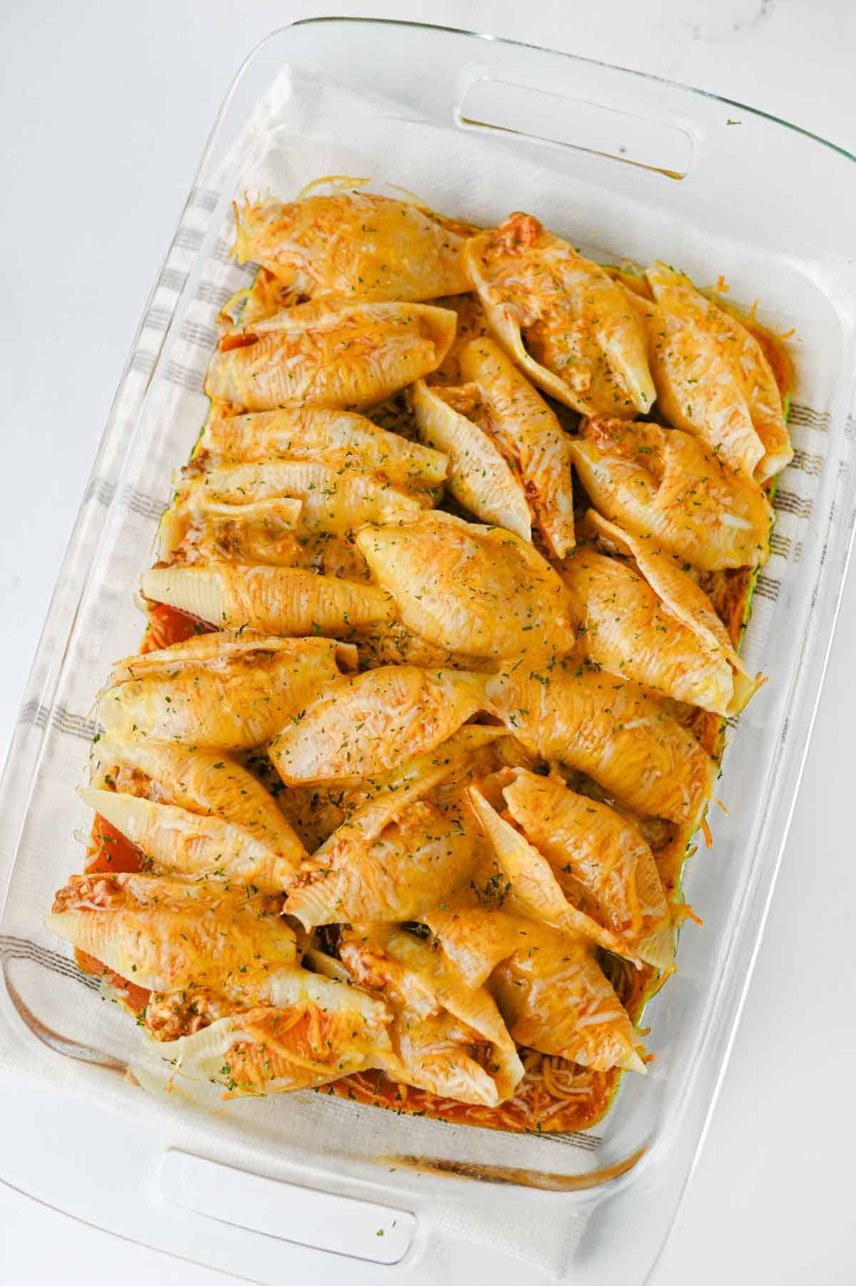 Mexican Stuffed Shells are an easy, cheesy dinner packed with bold Tex-Mex flavor! Jumbo pasta shells are filled with seasoned ground beef, taco seasoning, and cream cheese, then topped with enchilada sauce and shredded fiesta blend cheese before baking until hot and bubbly. This Mexican Stuffed Shells recipe is perfect when you need easy ground beef recipes for dinner, family friendly dinner ideas, quick weeknight meals, or a fun twist on classic stuffed shells. Add this cheesy ground beef casserole to your list of easy Mexican dinner recipes, taco inspired meals, pasta dinner ideas, and comfort food recipes. With simple ingredients and just 15 minutes of prep, these enchilada stuffed shells are great for busy nights, Taco Tuesday, or anytime you're craving cheesy Mexican pasta!
