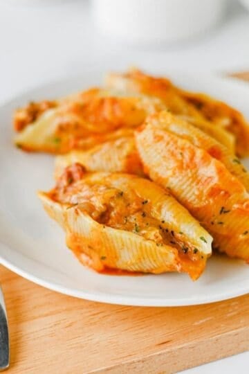 Mexican Stuffed Shells are an easy, cheesy dinner packed with bold Tex-Mex flavor! Jumbo pasta shells are filled with seasoned ground beef, taco seasoning, and cream cheese, then topped with enchilada sauce and shredded fiesta blend cheese before baking until hot and bubbly. This Mexican Stuffed Shells recipe is perfect when you need easy ground beef recipes for dinner, family friendly dinner ideas, quick weeknight meals, or a fun twist on classic stuffed shells. Add this cheesy ground beef casserole to your list of easy Mexican dinner recipes, taco inspired meals, pasta dinner ideas, and comfort food recipes. With simple ingredients and just 15 minutes of prep, these enchilada stuffed shells are great for busy nights, Taco Tuesday, or anytime you're craving cheesy Mexican pasta!