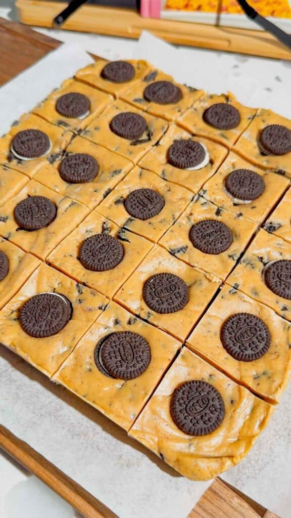 This Oreo Peanut Butter Fudge is the ultimate easy no bake dessert for peanut butter and chocolate lovers! Loaded with mini Reese’s Peanut Butter Cups, creamy peanut butter, peanut butter baking chips, vanilla frosting, and crunchy mini Oreos, this rich homemade fudge is packed with irresistible flavor. If you’re looking for Easy Fudge Recipes, Oreo Desserts, Peanut Butter Desserts, Reese’s Desserts, or No Bake Dessert Recipes, this simple treat is a must-try. Perfect for Christmas Candy, Holiday Desserts, Cookie Exchange Recipes, Party Desserts, Potluck Desserts, and homemade edible gifts, this Microwave Fudge Recipe takes just 15 minutes of prep. Save this Oreo Fudge Recipe when you need an easy dessert that combines cookies and cream with creamy peanut butter and Reese’s candy in every bite!