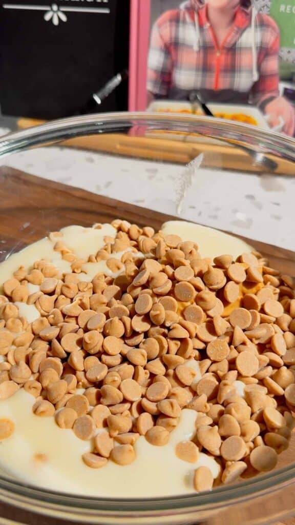 peanut butter baking chips, vanilla frosting and peanut butter in a mixing bowl after microwaving