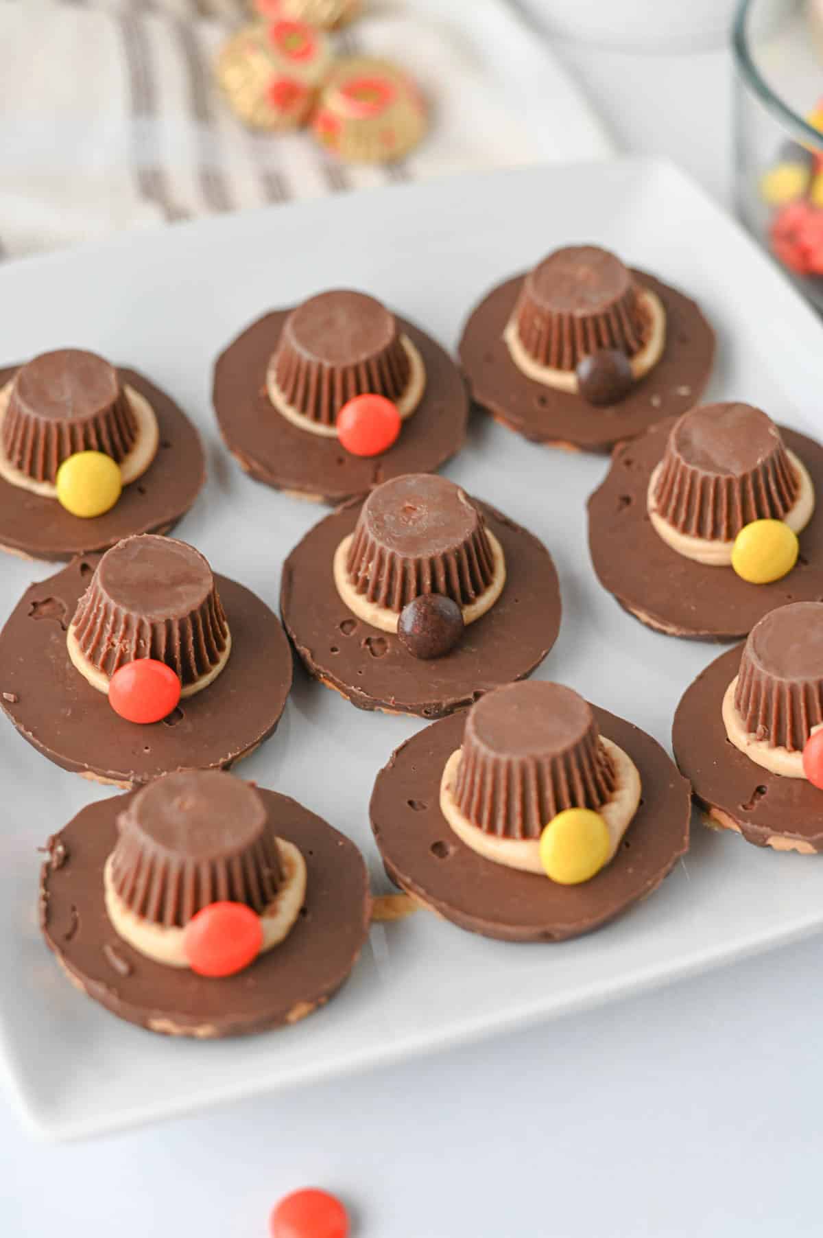These easy Pilgrim Hat Cookies are the cutest Thanksgiving dessert for your holiday table! Made with Keebler Fudge Stripe cookies, Reese's Peanut Butter Cups, Reese's Pieces and homemade peanut butter frosting, these no bake Thanksgiving cookies are fun, festive and simple to make. With just 20 minutes of prep, this easy Thanksgiving treat is perfect for kids, classroom parties, Friendsgiving, Thanksgiving dinner or a fall dessert table. If you're looking for cute Thanksgiving cookies, easy Thanksgiving desserts, no bake fall treats, Thanksgiving food ideas for kids or simple holiday desserts, these chocolate peanut butter Pilgrim Hat Cookies are a must-try. Save this easy Thanksgiving cookie recipe for a edible craft, party treat or quick Thanksgiving dessert everyone will want to grab!