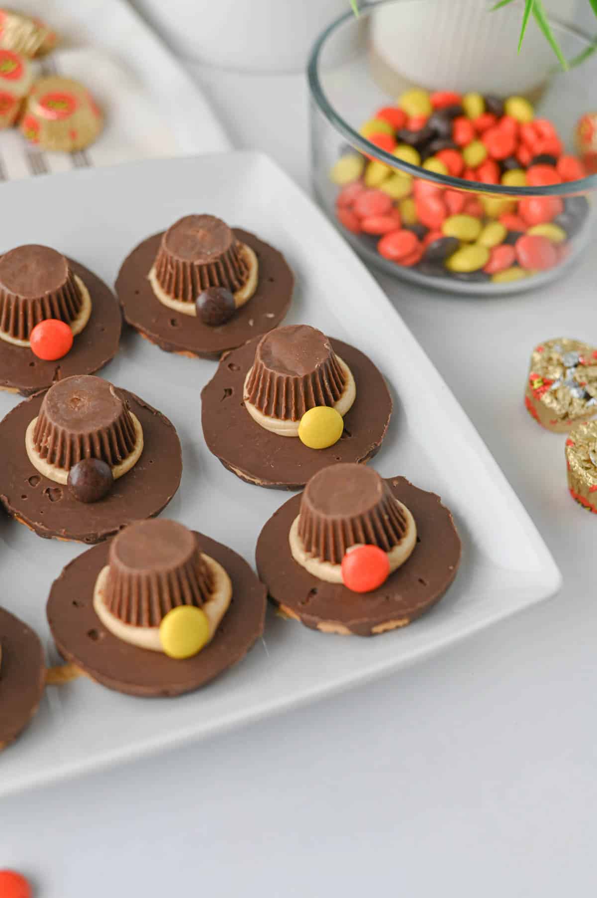These easy Pilgrim Hat Cookies are the cutest Thanksgiving dessert for your holiday table! Made with Keebler Fudge Stripe cookies, Reese's Peanut Butter Cups, Reese's Pieces and homemade peanut butter frosting, these no bake Thanksgiving cookies are fun, festive and simple to make. With just 20 minutes of prep, this easy Thanksgiving treat is perfect for kids, classroom parties, Friendsgiving, Thanksgiving dinner or a fall dessert table. If you're looking for cute Thanksgiving cookies, easy Thanksgiving desserts, no bake fall treats, Thanksgiving food ideas for kids or simple holiday desserts, these chocolate peanut butter Pilgrim Hat Cookies are a must-try. Save this easy Thanksgiving cookie recipe for a edible craft, party treat or quick Thanksgiving dessert everyone will want to grab!