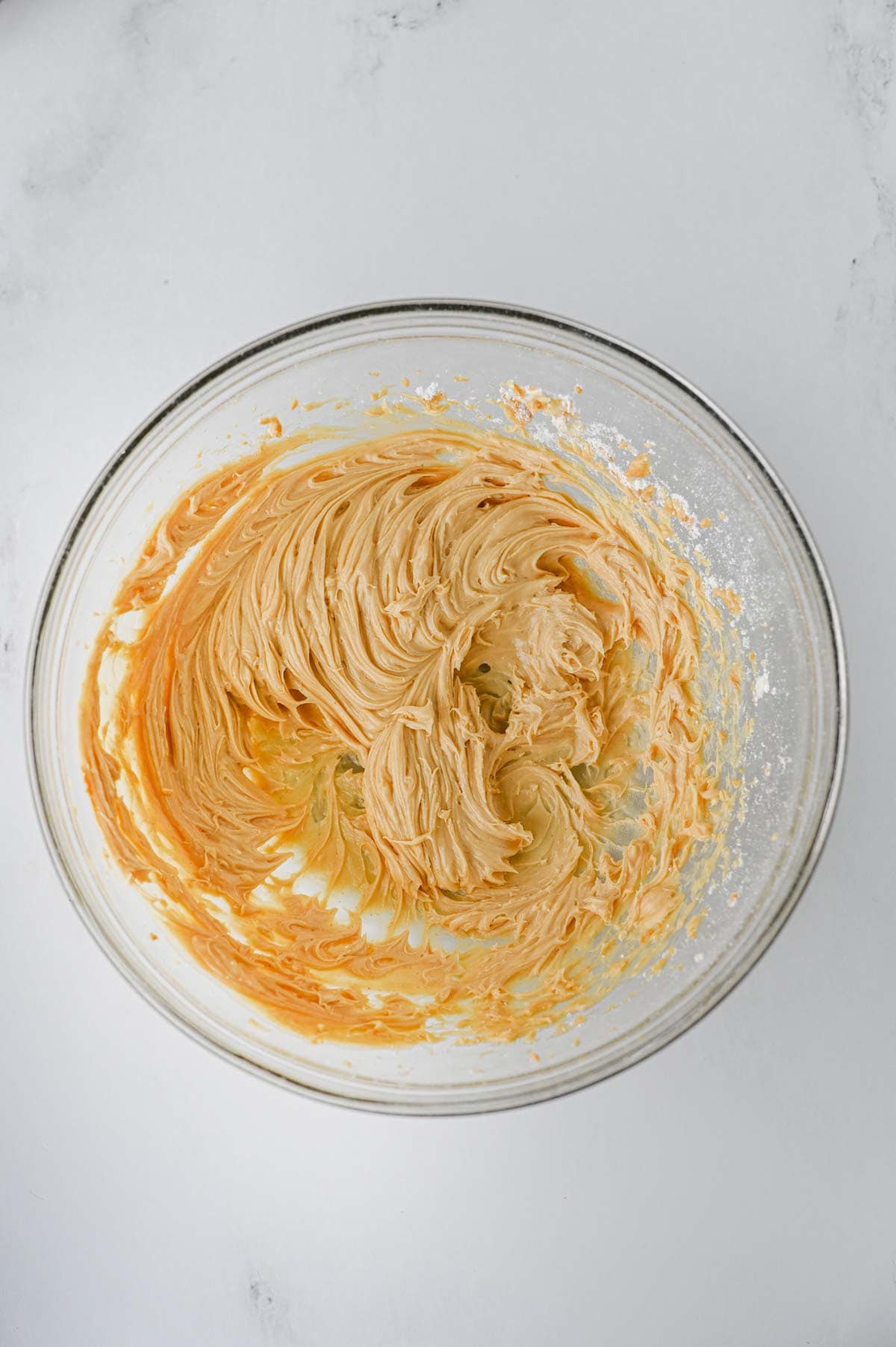 peanut butter frosting in a glass mixing bowl