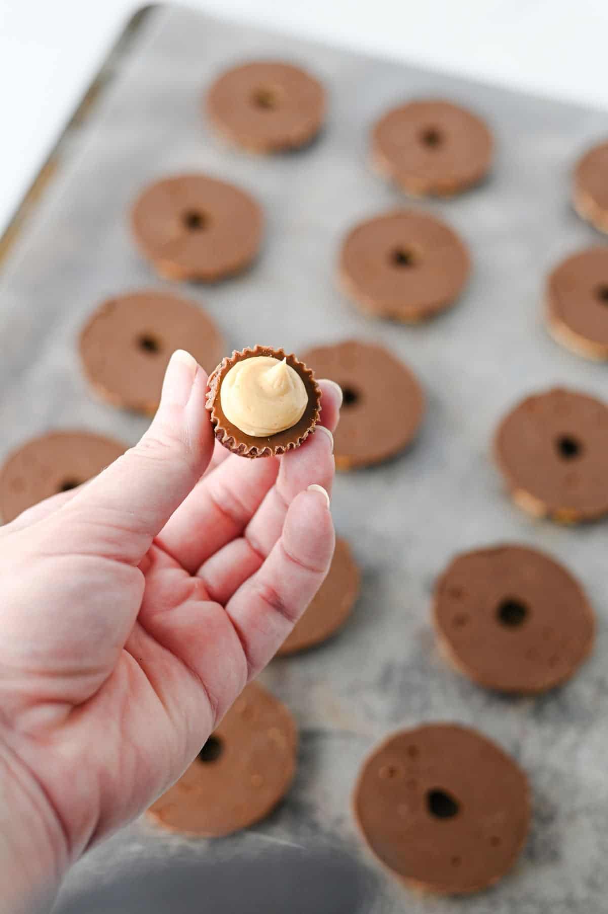 peanut butter frosting on top of a mini Reese's peanut butter cup