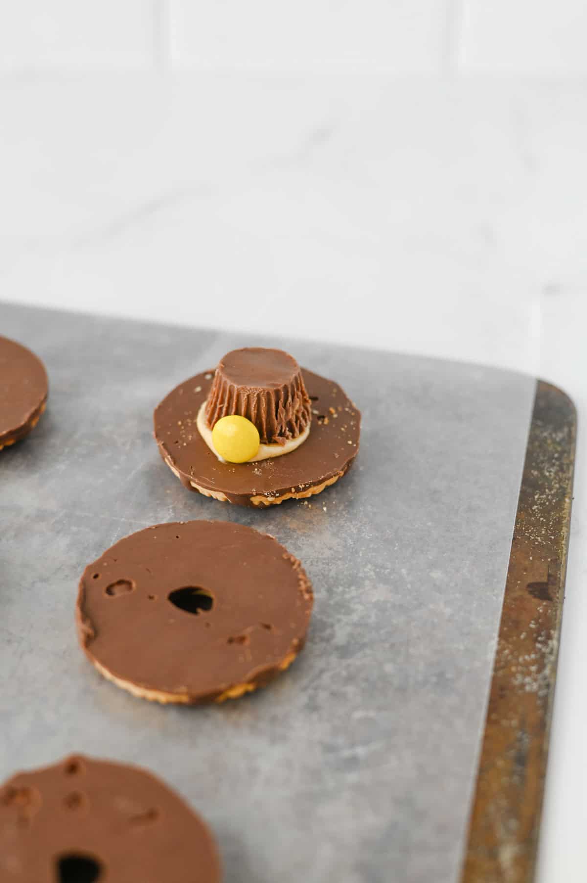 These easy Pilgrim Hat Cookies are the cutest Thanksgiving dessert for your holiday table! Made with Keebler Fudge Stripe cookies, Reese's Peanut Butter Cups, Reese's Pieces and homemade peanut butter frosting, these no bake Thanksgiving cookies are fun, festive and simple to make. With just 20 minutes of prep, this easy Thanksgiving treat is perfect for kids, classroom parties, Friendsgiving, Thanksgiving dinner or a fall dessert table. If you're looking for cute Thanksgiving cookies, easy Thanksgiving desserts, no bake fall treats, Thanksgiving food ideas for kids or simple holiday desserts, these chocolate peanut butter Pilgrim Hat Cookies are a must-try. Save this easy Thanksgiving cookie recipe for a edible craft, party treat or quick Thanksgiving dessert everyone will want to grab!