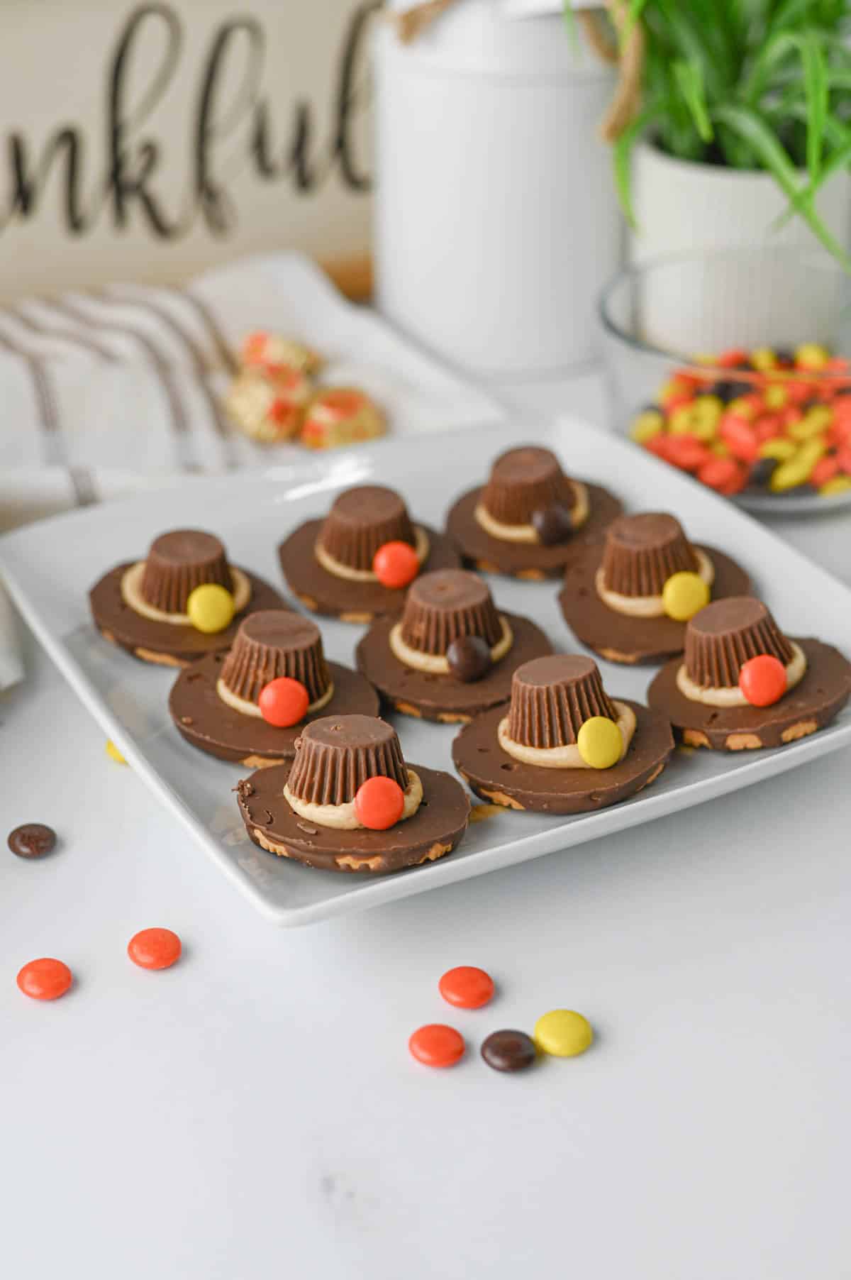 These easy Pilgrim Hat Cookies are the cutest Thanksgiving dessert for your holiday table! Made with Keebler Fudge Stripe cookies, Reese's Peanut Butter Cups, Reese's Pieces and homemade peanut butter frosting, these no bake Thanksgiving cookies are fun, festive and simple to make. With just 20 minutes of prep, this easy Thanksgiving treat is perfect for kids, classroom parties, Friendsgiving, Thanksgiving dinner or a fall dessert table. If you're looking for cute Thanksgiving cookies, easy Thanksgiving desserts, no bake fall treats, Thanksgiving food ideas for kids or simple holiday desserts, these chocolate peanut butter Pilgrim Hat Cookies are a must-try. Save this easy Thanksgiving cookie recipe for a edible craft, party treat or quick Thanksgiving dessert everyone will want to grab!