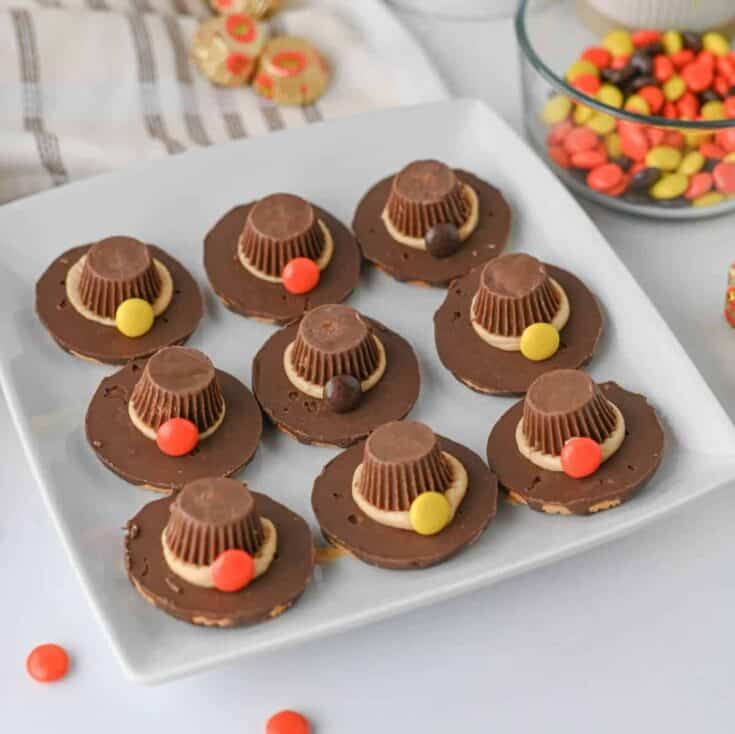 These easy Pilgrim Hat Cookies are the cutest Thanksgiving dessert for your holiday table! Made with Keebler Fudge Stripe cookies, Reese's Peanut Butter Cups, Reese's Pieces and homemade peanut butter frosting, these no bake Thanksgiving cookies are fun, festive and simple to make. With just 20 minutes of prep, this easy Thanksgiving treat is perfect for kids, classroom parties, Friendsgiving, Thanksgiving dinner or a fall dessert table. If you're looking for cute Thanksgiving cookies, easy Thanksgiving desserts, no bake fall treats, Thanksgiving food ideas for kids or simple holiday desserts, these chocolate peanut butter Pilgrim Hat Cookies are a must-try. Save this easy Thanksgiving cookie recipe for a edible craft, party treat or quick Thanksgiving dessert everyone will want to grab!