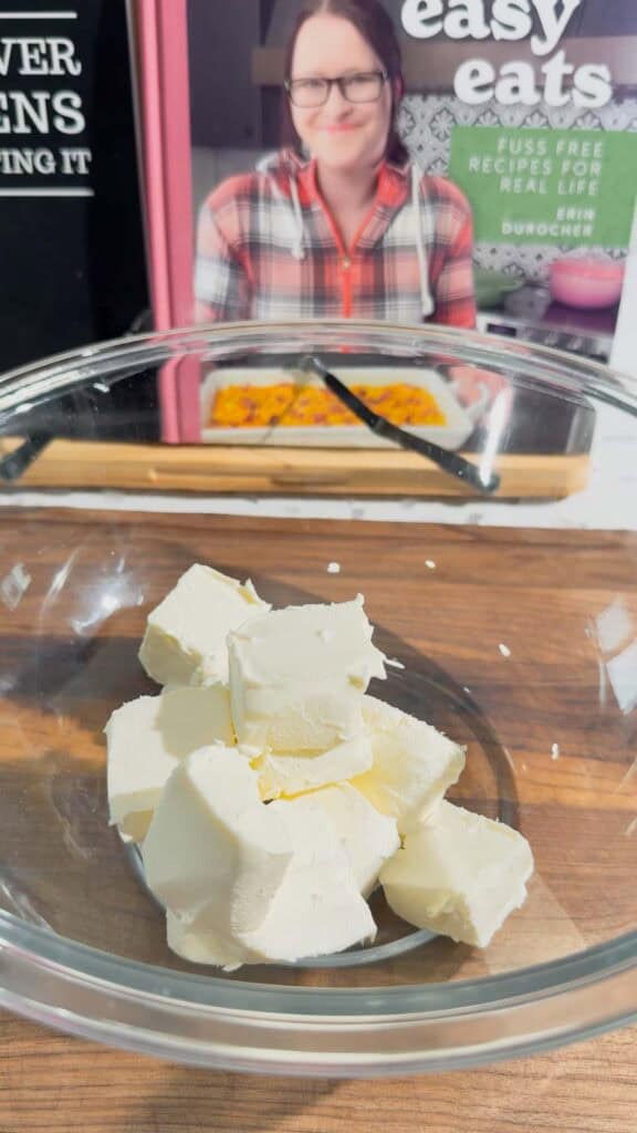 cubed cream cheese in a glass mixing bowl