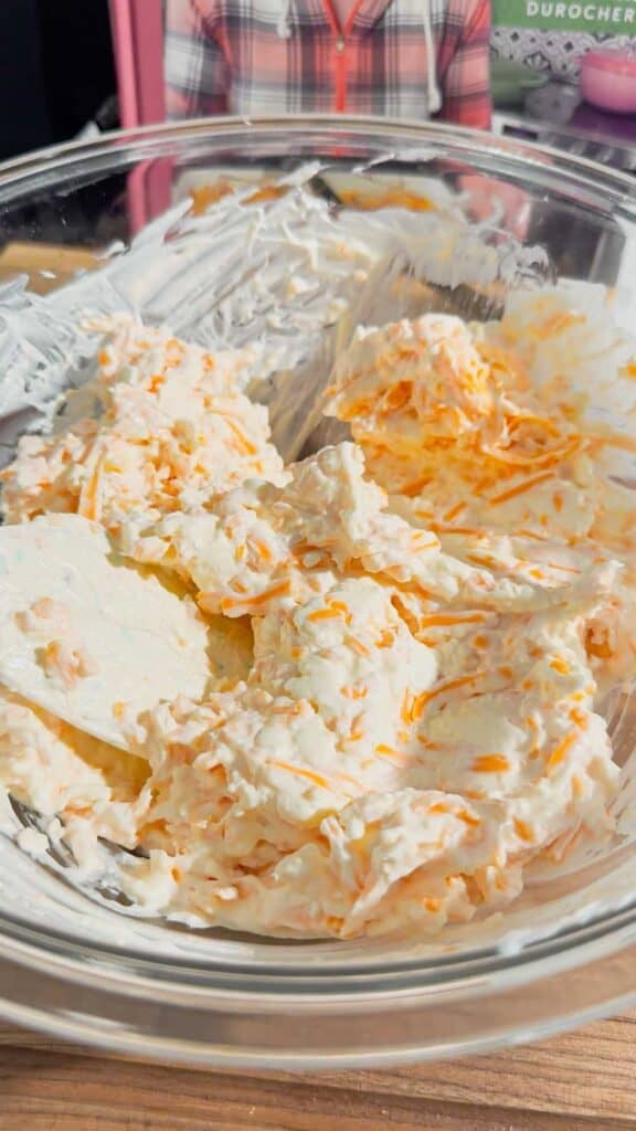 cream cheese, mayo and shredded cheddar cheese mixture in a glass mixing bowl