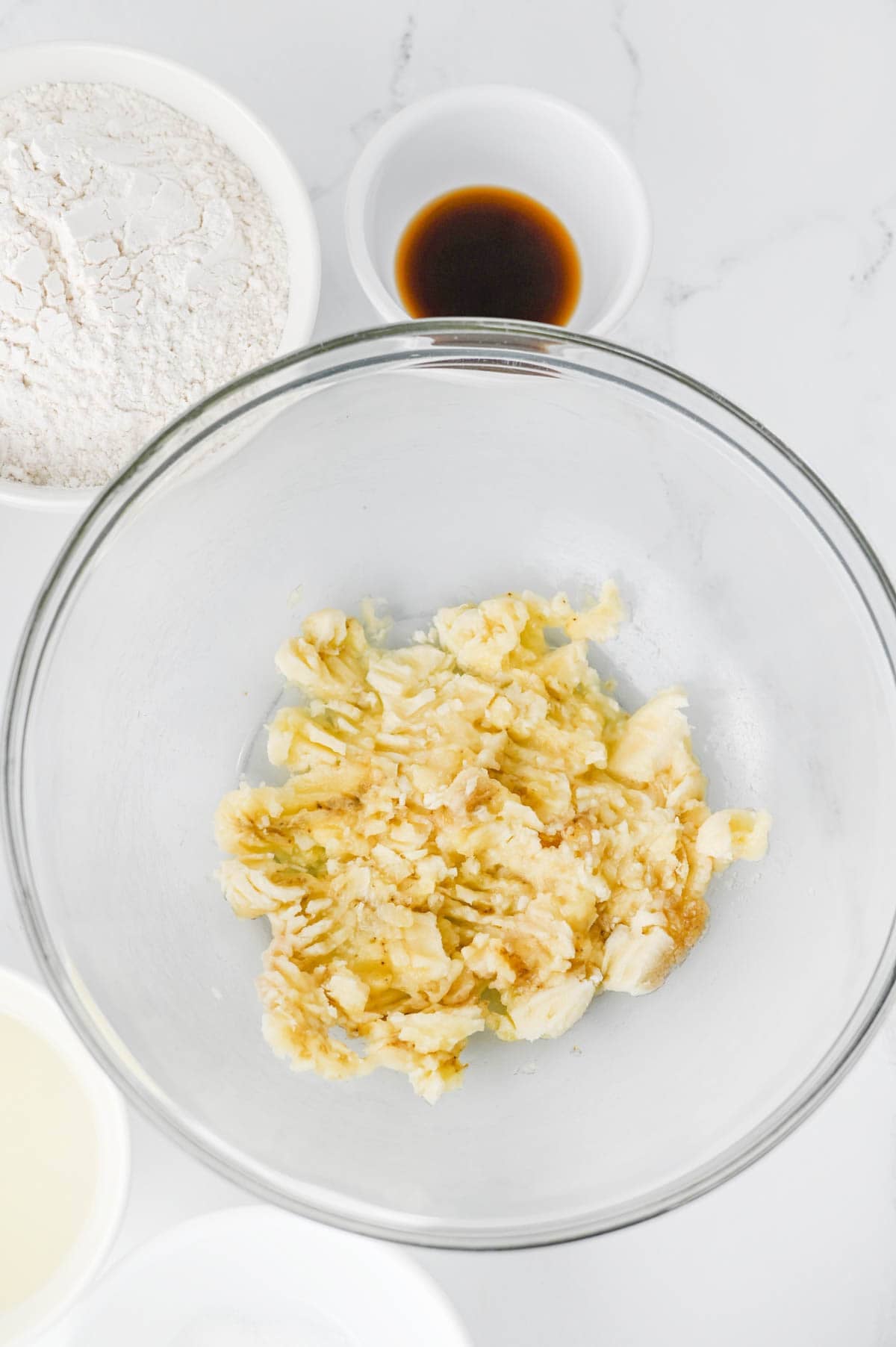 mashed bananas in glass mixing bowl