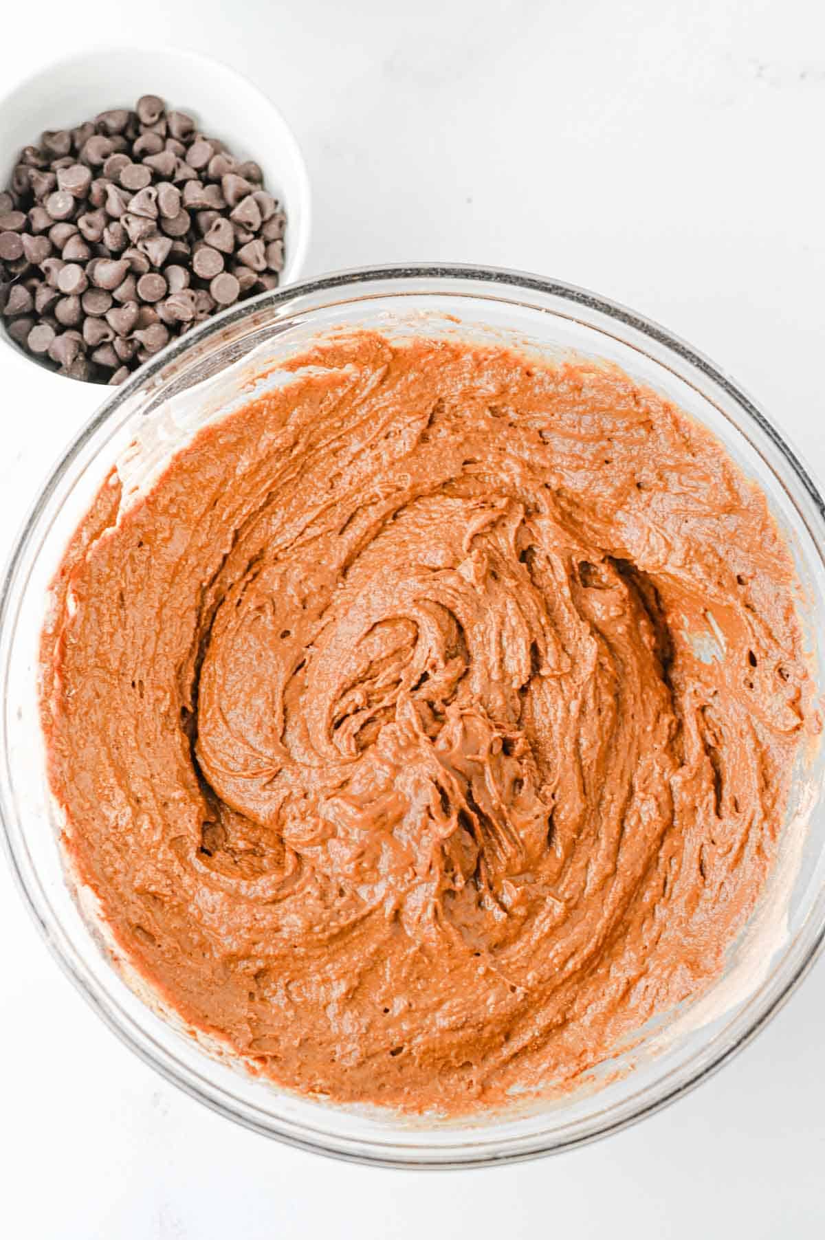 pumpkin chocolate muffin batter in a glass mixing bowl