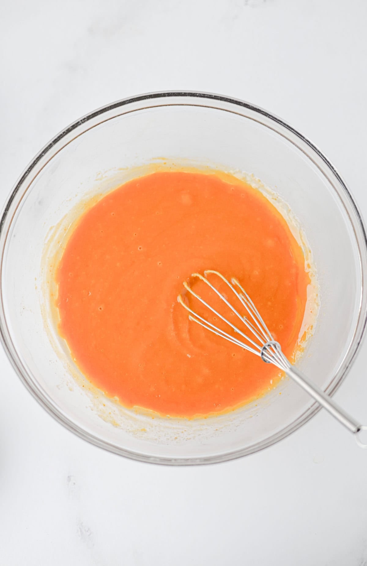 pumpkin puree and other wet ingredients whisked together in a mixing bowl