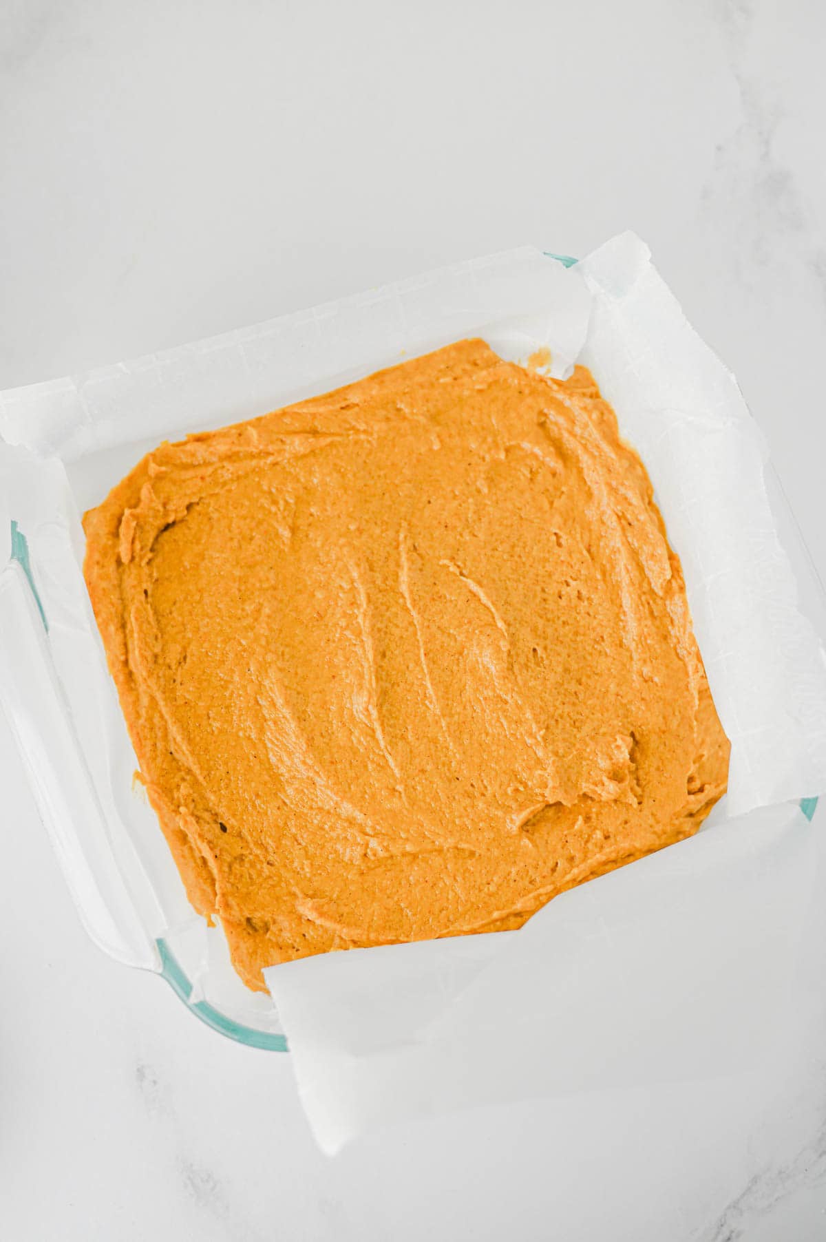 pumpkin coffee cake batter in a parchment lined baking dish