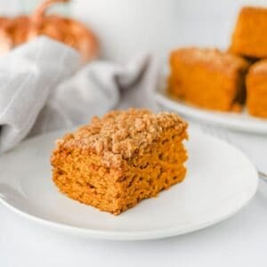 This Pumpkin Coffee Cake is the ultimate cozy fall baking recipe, made with pumpkin puree, warm cinnamon, nutmeg, ginger, brown sugar, and a touch of maple syrup. This easy Pumpkin Coffee Cake Recipe is soft, moist, and topped with a buttery cinnamon brown sugar crumb topping for the perfect sweet crunch. Add the simple powdered sugar icing for an extra decadent finish! If you're looking for Easy Pumpkin Desserts, Pumpkin Breakfast Recipes, Fall Baking Ideas, Pumpkin Spice Recipes, or delicious Fall Brunch Recipes, this homemade coffee cake is a must-try. It's perfect for Thanksgiving breakfast, holiday brunch, weekend baking, or enjoying with a hot cup of coffee. Save this Easy Pumpkin Coffee Cake for pumpkin season when you need a simple Pumpkin Dessert that's packed with cozy fall flavor!