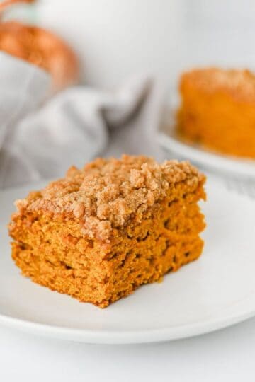 This Pumpkin Coffee Cake is the ultimate cozy fall baking recipe, made with pumpkin puree, warm cinnamon, nutmeg, ginger, brown sugar, and a touch of maple syrup. This easy Pumpkin Coffee Cake Recipe is soft, moist, and topped with a buttery cinnamon brown sugar crumb topping for the perfect sweet crunch. Add the simple powdered sugar icing for an extra decadent finish! If you're looking for Easy Pumpkin Desserts, Pumpkin Breakfast Recipes, Fall Baking Ideas, Pumpkin Spice Recipes, or delicious Fall Brunch Recipes, this homemade coffee cake is a must-try. It's perfect for Thanksgiving breakfast, holiday brunch, weekend baking, or enjoying with a hot cup of coffee. Save this Easy Pumpkin Coffee Cake for pumpkin season when you need a simple Pumpkin Dessert that's packed with cozy fall flavor!