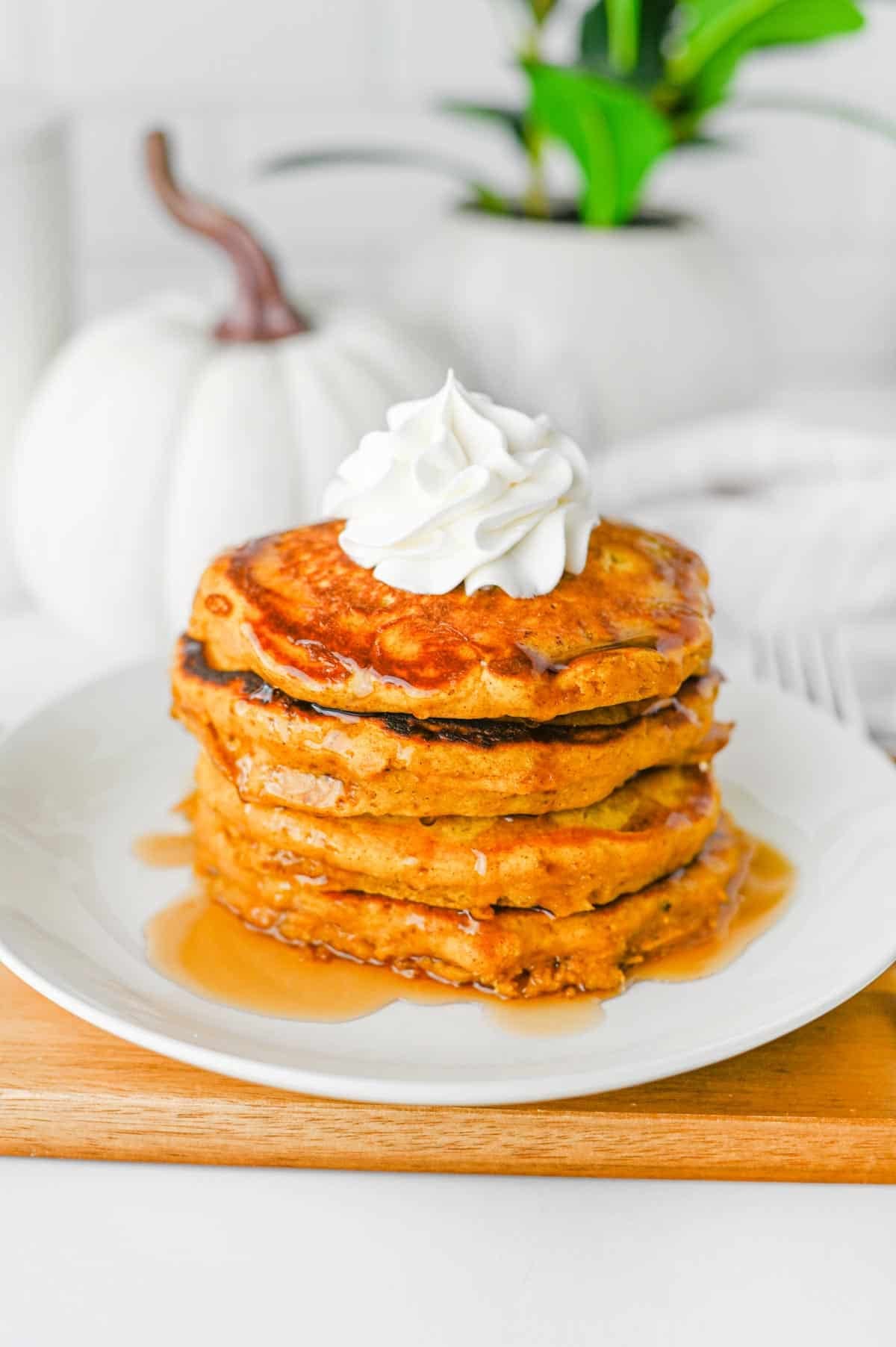 These fluffy Pumpkin Pancakes are the ultimate cozy fall breakfast, made with pumpkin puree, pumpkin pie spice, cinnamon, brown sugar and melted butter for warm autumn flavor in every bite. This easy Pumpkin Pancakes Recipe makes soft, thick and fluffy pancakes that are perfect for weekend breakfasts, Thanksgiving morning, Halloween breakfast or a fall brunch. If you're looking for Easy Pumpkin Pancakes, Pumpkin Breakfast Recipes, Fall Breakfast Ideas or recipes using pumpkin puree, save this one! Top these homemade pumpkin pancakes with butter, maple syrup, whipped cream, chopped pecans or walnuts and an extra sprinkle of pumpkin pie spice. These Pumpkin Spice Pancakes are an easy way to use canned pumpkin and make a delicious breakfast for the whole family during pumpkin season.