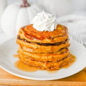 These fluffy Pumpkin Pancakes are the ultimate cozy fall breakfast, made with pumpkin puree, pumpkin pie spice, cinnamon, brown sugar and melted butter for warm autumn flavor in every bite. This easy Pumpkin Pancakes Recipe makes soft, thick and fluffy pancakes that are perfect for weekend breakfasts, Thanksgiving morning, Halloween breakfast or a fall brunch. If you're looking for Easy Pumpkin Pancakes, Pumpkin Breakfast Recipes, Fall Breakfast Ideas or recipes using pumpkin puree, save this one! Top these homemade pumpkin pancakes with butter, maple syrup, whipped cream, chopped pecans or walnuts and an extra sprinkle of pumpkin pie spice. These Pumpkin Spice Pancakes are an easy way to use canned pumpkin and make a delicious breakfast for the whole family during pumpkin season.