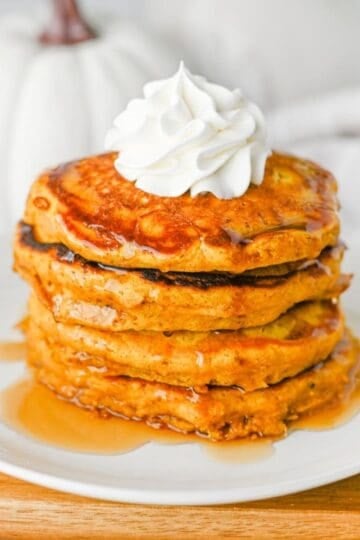 These fluffy Pumpkin Pancakes are the ultimate cozy fall breakfast, made with pumpkin puree, pumpkin pie spice, cinnamon, brown sugar and melted butter for warm autumn flavor in every bite. This easy Pumpkin Pancakes Recipe makes soft, thick and fluffy pancakes that are perfect for weekend breakfasts, Thanksgiving morning, Halloween breakfast or a fall brunch. If you're looking for Easy Pumpkin Pancakes, Pumpkin Breakfast Recipes, Fall Breakfast Ideas or recipes using pumpkin puree, save this one! Top these homemade pumpkin pancakes with butter, maple syrup, whipped cream, chopped pecans or walnuts and an extra sprinkle of pumpkin pie spice. These Pumpkin Spice Pancakes are an easy way to use canned pumpkin and make a delicious breakfast for the whole family during pumpkin season.