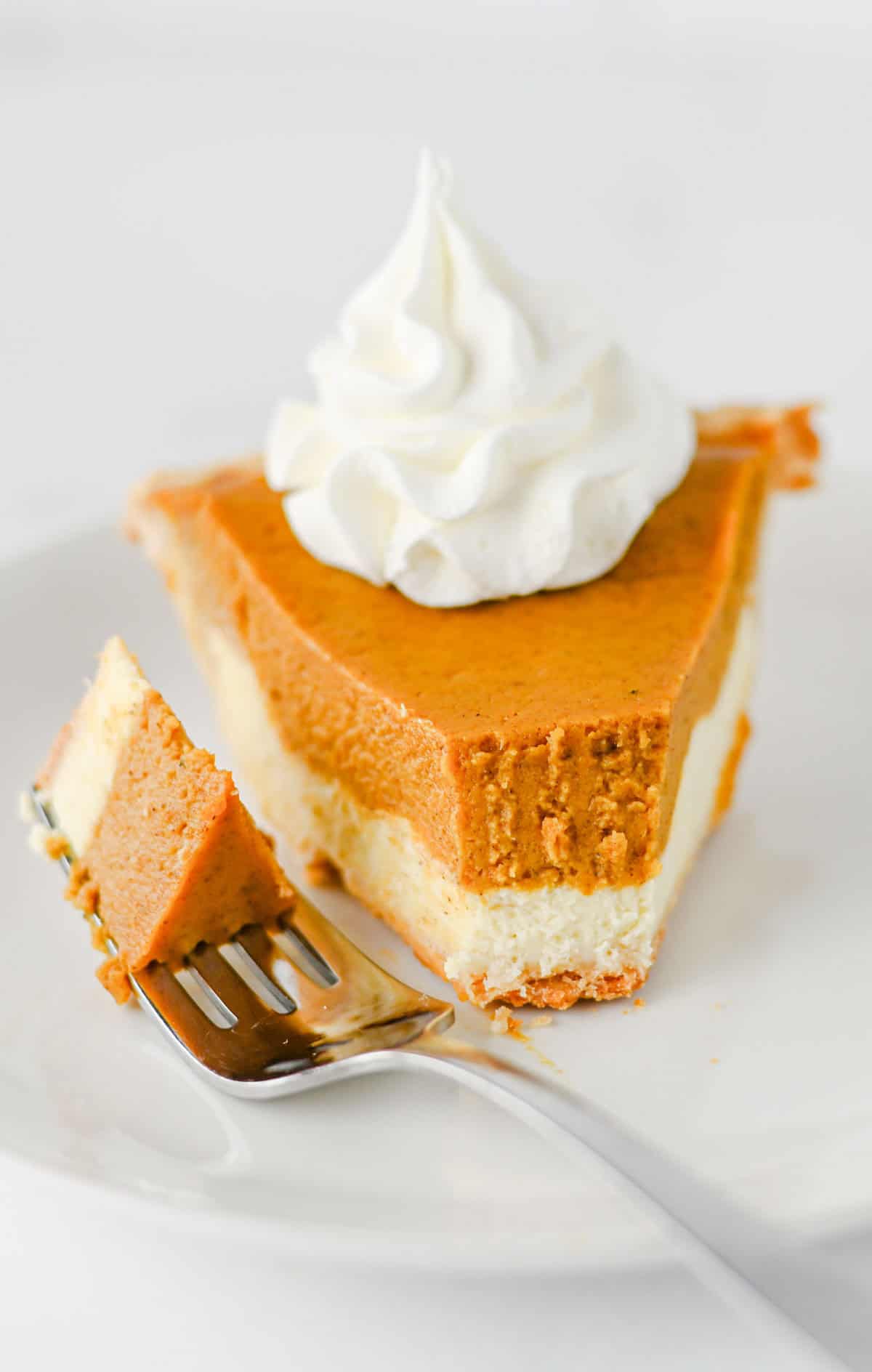 Pumpkin Pie Cheesecake is the perfect fall dessert when you can’t decide between classic pumpkin pie and creamy cheesecake! This easy Pumpkin Pie Cheesecake Recipe starts with a premade flaky pie crust and layers a sweet vanilla cream cheese filling with a rich pumpkin pie filling made with pumpkin puree, brown sugar, pumpkin pie spice, eggs, and heavy cream. It’s a delicious Thanksgiving dessert, holiday pie recipe, and fall baking idea for family dinners, potlucks, Friendsgiving, or Christmas. If you love easy pumpkin desserts, pumpkin cheesecake recipes, homemade pumpkin pie, and creamy cheesecake, this layered dessert is a must-try. Save this easy pumpkin cheesecake pie for your fall dessert recipes, Thanksgiving pie ideas, holiday baking, and pumpkin recipes to make all season long!