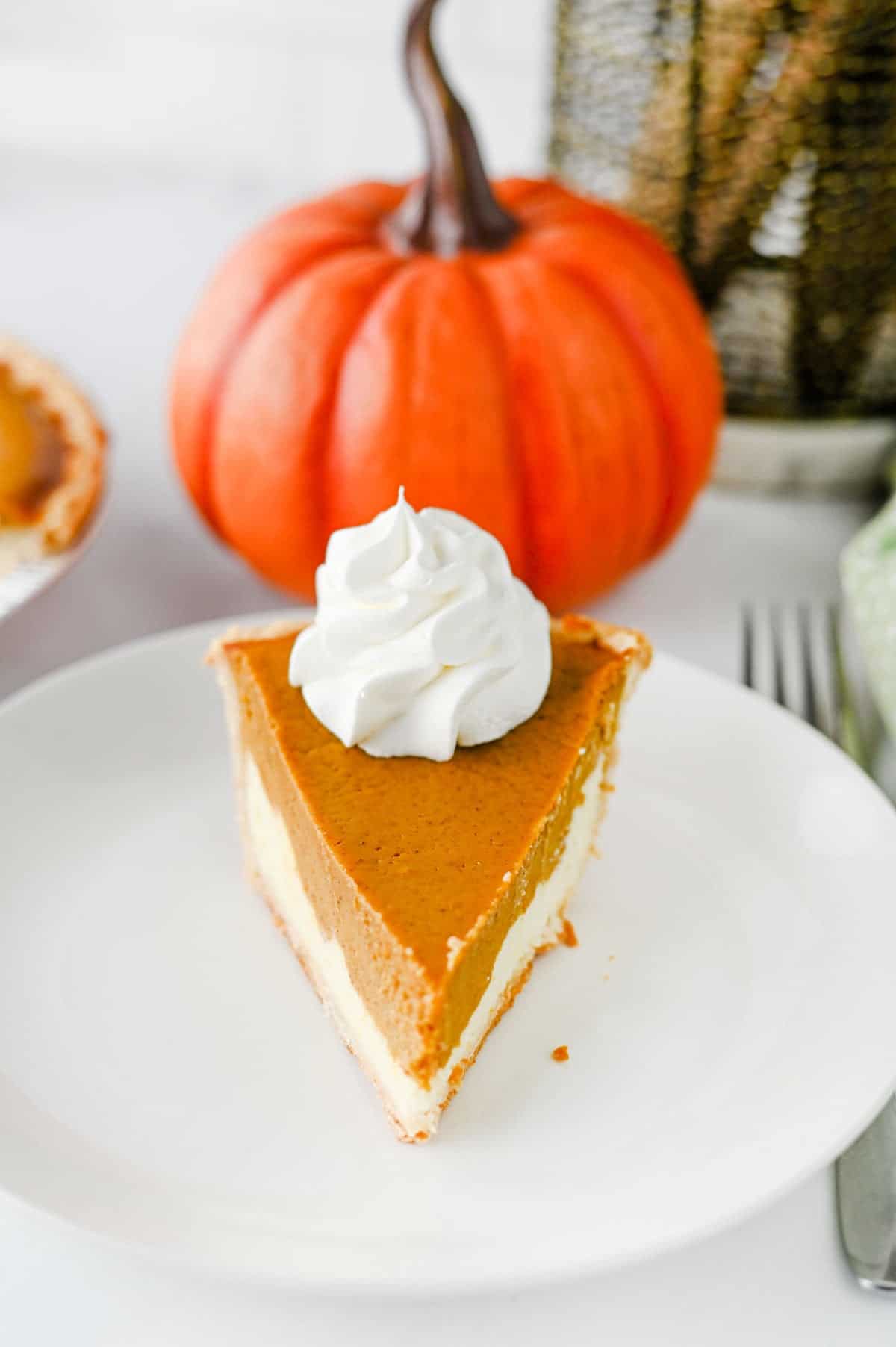 Pumpkin Pie Cheesecake is the perfect fall dessert when you can’t decide between classic pumpkin pie and creamy cheesecake! This easy Pumpkin Pie Cheesecake Recipe starts with a premade flaky pie crust and layers a sweet vanilla cream cheese filling with a rich pumpkin pie filling made with pumpkin puree, brown sugar, pumpkin pie spice, eggs, and heavy cream. It’s a delicious Thanksgiving dessert, holiday pie recipe, and fall baking idea for family dinners, potlucks, Friendsgiving, or Christmas. If you love easy pumpkin desserts, pumpkin cheesecake recipes, homemade pumpkin pie, and creamy cheesecake, this layered dessert is a must-try. Save this easy pumpkin cheesecake pie for your fall dessert recipes, Thanksgiving pie ideas, holiday baking, and pumpkin recipes to make all season long!