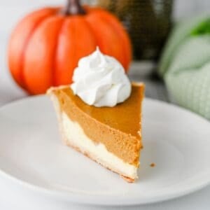 Pumpkin Pie Cheesecake is the perfect fall dessert when you can’t decide between classic pumpkin pie and creamy cheesecake! This easy Pumpkin Pie Cheesecake Recipe starts with a premade flaky pie crust and layers a sweet vanilla cream cheese filling with a rich pumpkin pie filling made with pumpkin puree, brown sugar, pumpkin pie spice, eggs, and heavy cream. It’s a delicious Thanksgiving dessert, holiday pie recipe, and fall baking idea for family dinners, potlucks, Friendsgiving, or Christmas. If you love easy pumpkin desserts, pumpkin cheesecake recipes, homemade pumpkin pie, and creamy cheesecake, this layered dessert is a must-try. Save this easy pumpkin cheesecake pie for your fall dessert recipes, Thanksgiving pie ideas, holiday baking, and pumpkin recipes to make all season long!