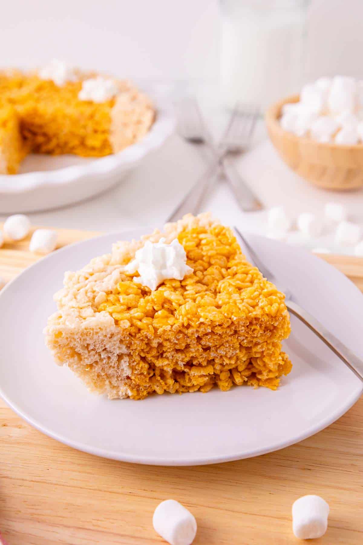 These Pumpkin Rice Krispie Treats are a fun fall dessert that turns classic marshmallow cereal treats into an adorable pumpkin pie! Made with buttery Rice Krispies, pumpkin puree, pumpkin pie spice and orange food coloring, this easy no bake dessert is perfect for Halloween parties, Thanksgiving dessert tables and fall gatherings. If you’re looking for easy pumpkin desserts, Halloween Rice Krispie treats, no bake fall desserts or easy fall treats for kids, this festive recipe is a must-try. The crispy Rice Krispie crust surrounds a soft, chewy pumpkin-spiced center that looks just like pumpkin pie. Add whipped topping before serving for a festive finish everyone will love. Save these Pumpkin Rice Krispie Treats for your fall baking, Halloween dessert and Thanksgiving treat ideas!