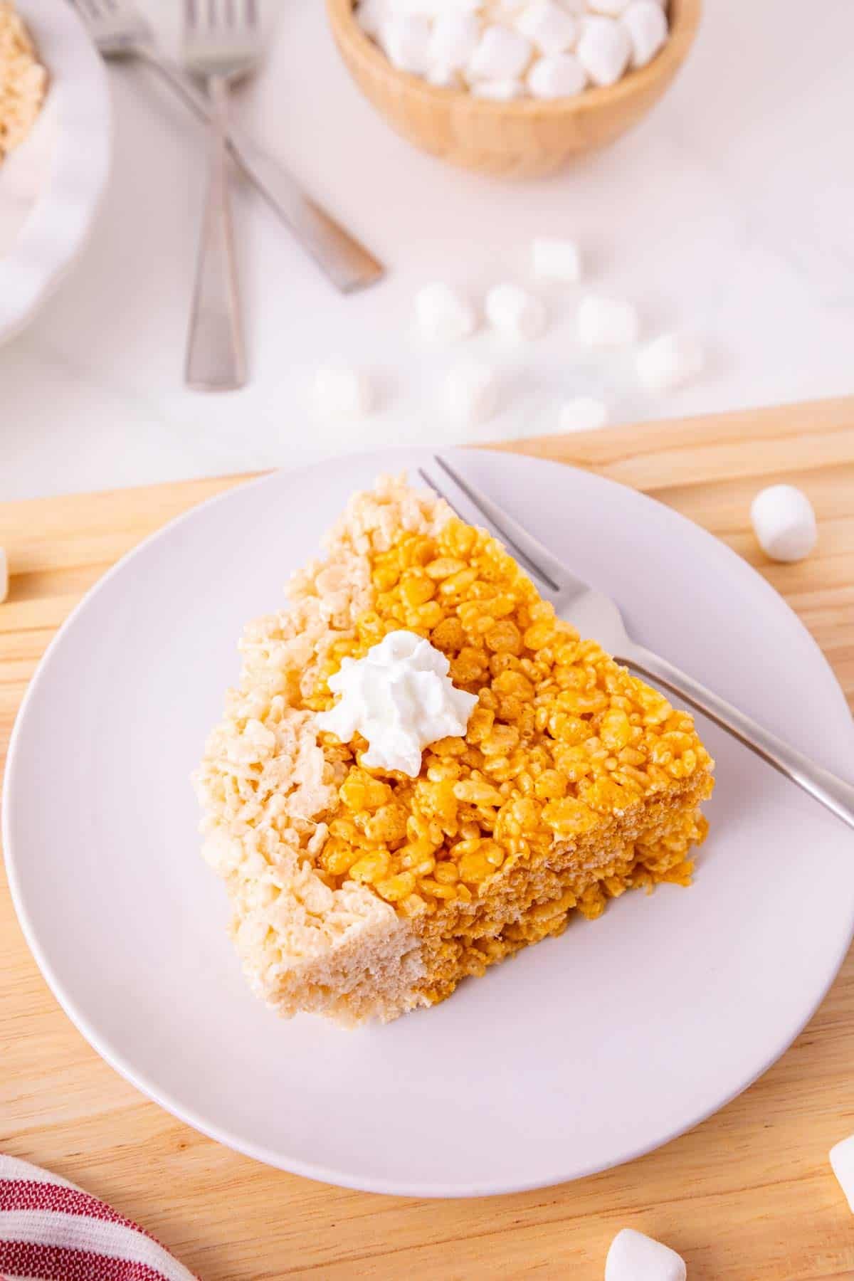 These Pumpkin Rice Krispie Treats are a fun fall dessert that turns classic marshmallow cereal treats into an adorable pumpkin pie! Made with buttery Rice Krispies, pumpkin puree, pumpkin pie spice and orange food coloring, this easy no bake dessert is perfect for Halloween parties, Thanksgiving dessert tables and fall gatherings. If you’re looking for easy pumpkin desserts, Halloween Rice Krispie treats, no bake fall desserts or easy fall treats for kids, this festive recipe is a must-try. The crispy Rice Krispie crust surrounds a soft, chewy pumpkin-spiced center that looks just like pumpkin pie. Add whipped topping before serving for a festive finish everyone will love. Save these Pumpkin Rice Krispie Treats for your fall baking, Halloween dessert and Thanksgiving treat ideas!