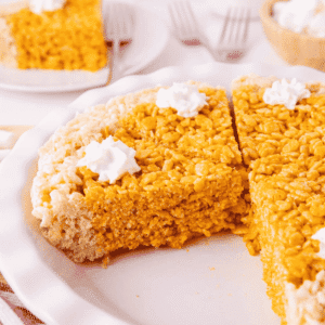 These Pumpkin Rice Krispie Treats are a fun fall dessert that turns classic marshmallow cereal treats into an adorable pumpkin pie! Made with buttery Rice Krispies, pumpkin puree, pumpkin pie spice and orange food coloring, this easy no bake dessert is perfect for Halloween parties, Thanksgiving dessert tables and fall gatherings. If you’re looking for easy pumpkin desserts, Halloween Rice Krispie treats, no bake fall desserts or easy fall treats for kids, this festive recipe is a must-try. The crispy Rice Krispie crust surrounds a soft, chewy pumpkin-spiced center that looks just like pumpkin pie. Add whipped topping before serving for a festive finish everyone will love. Save these Pumpkin Rice Krispie Treats for your fall baking, Halloween dessert and Thanksgiving treat ideas!