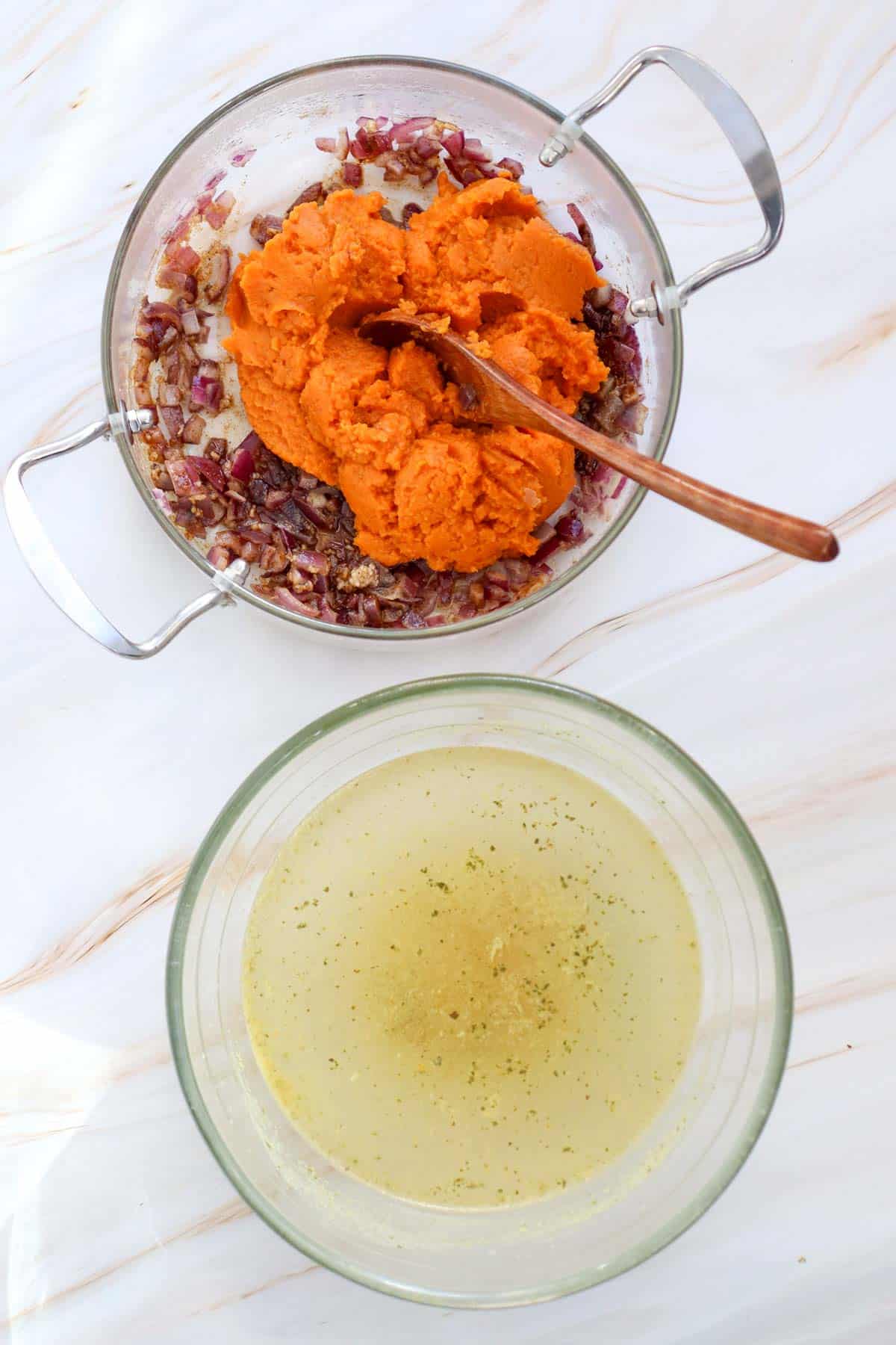 pumpkin puree added to soup pot with vegetables and seasonings