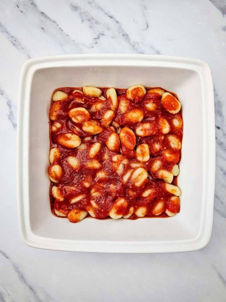 gnocchi covered in tomato sauce in a baking dish