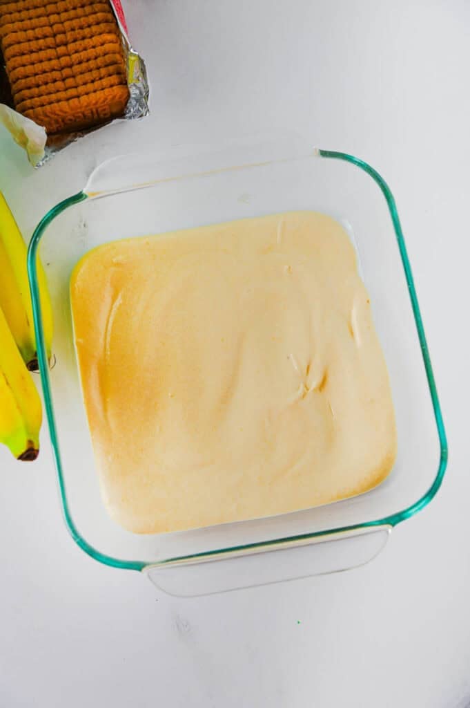 vanilla pudding mixture in the bottom of a glass baking dish