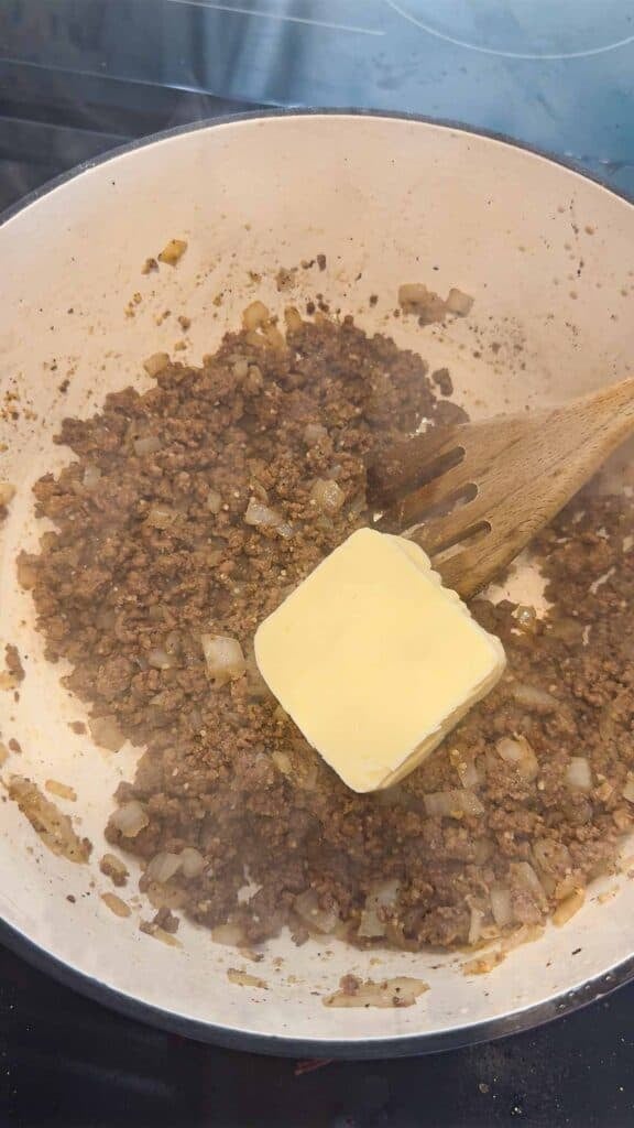 butter added to a pot with cooked ground beef