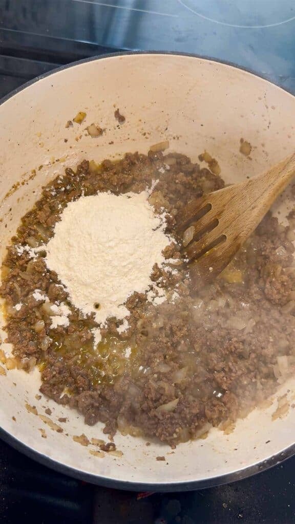 flour on top of ground beef in a large pot