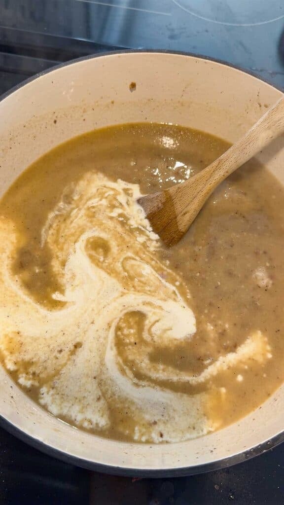 heavy cream added to soup in a pot
