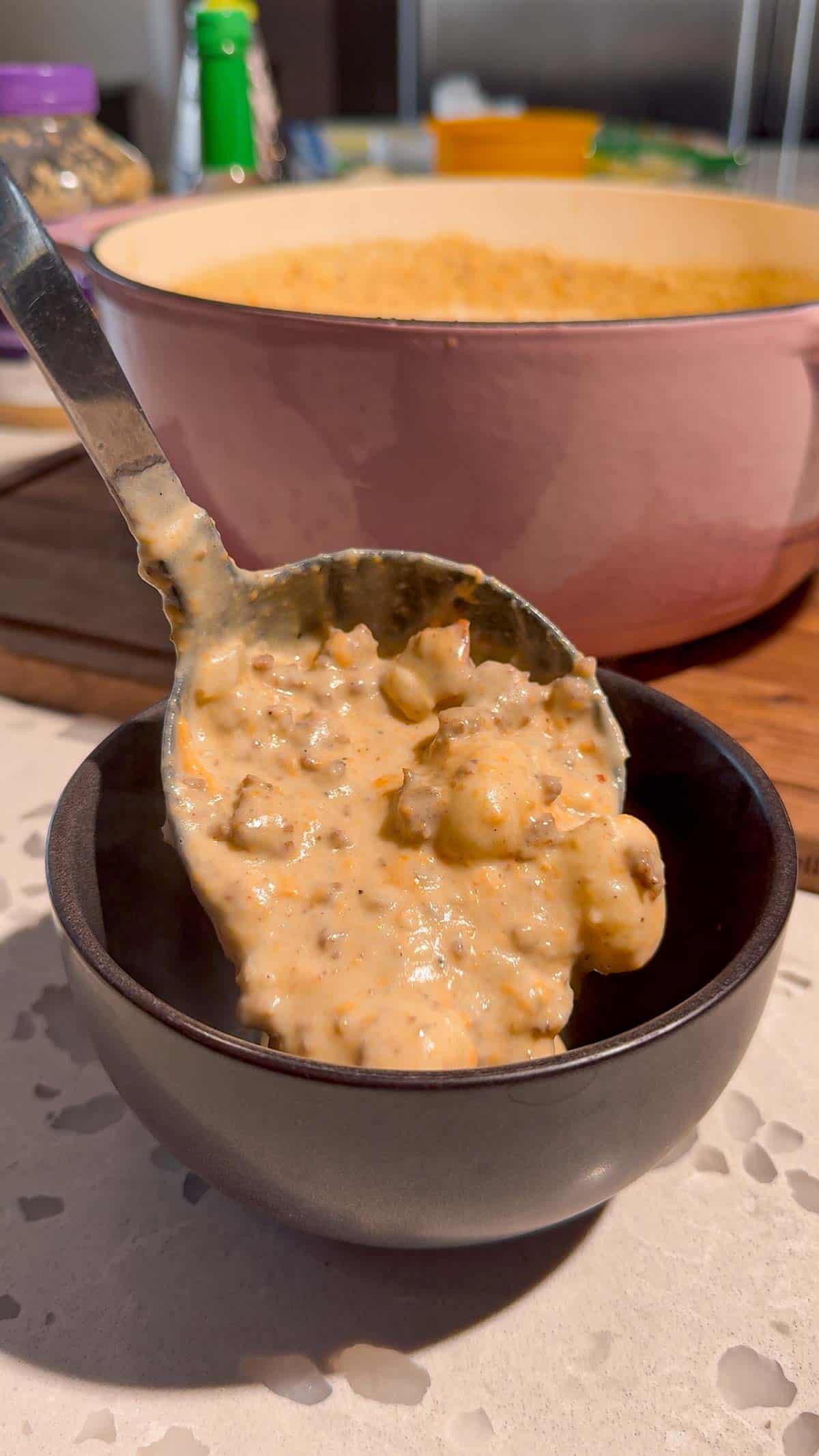 ladling cheeseburger gnocchi soup into a bowl