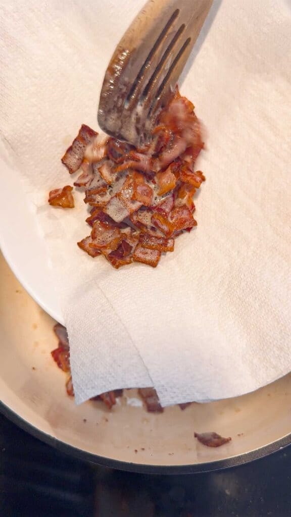 cooked bacon pieces on a paper towel lined plate