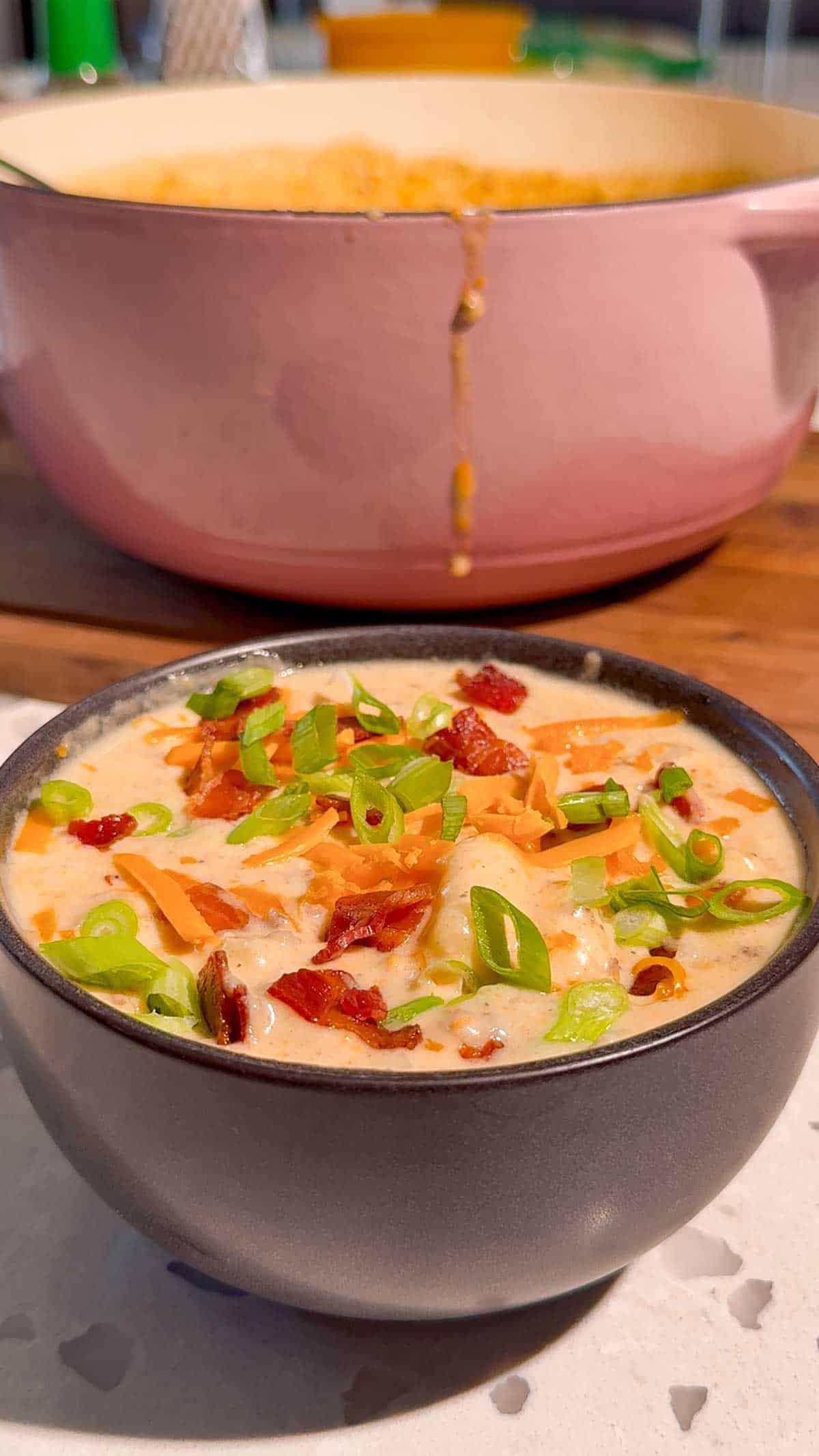 green onions and shredded cheddar on top of cheeseburger gnocchi soup