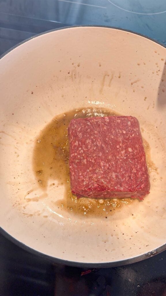 raw ground beef cooking in a pot